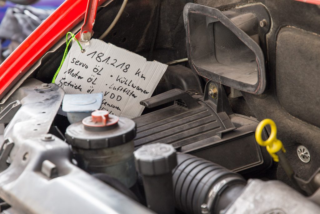 Handgeschriebener Service-Anhänger aus Pappe im Motorraum des T4