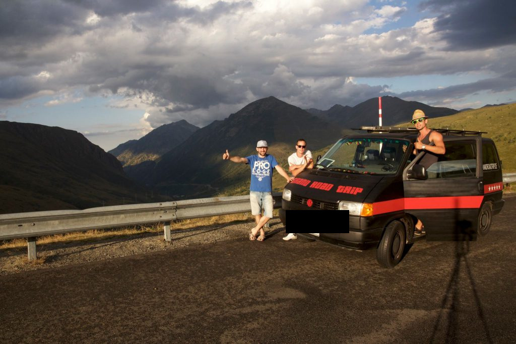 Die Crew posiert vor dem Bus, dahinter die Berge der Pyrenäen