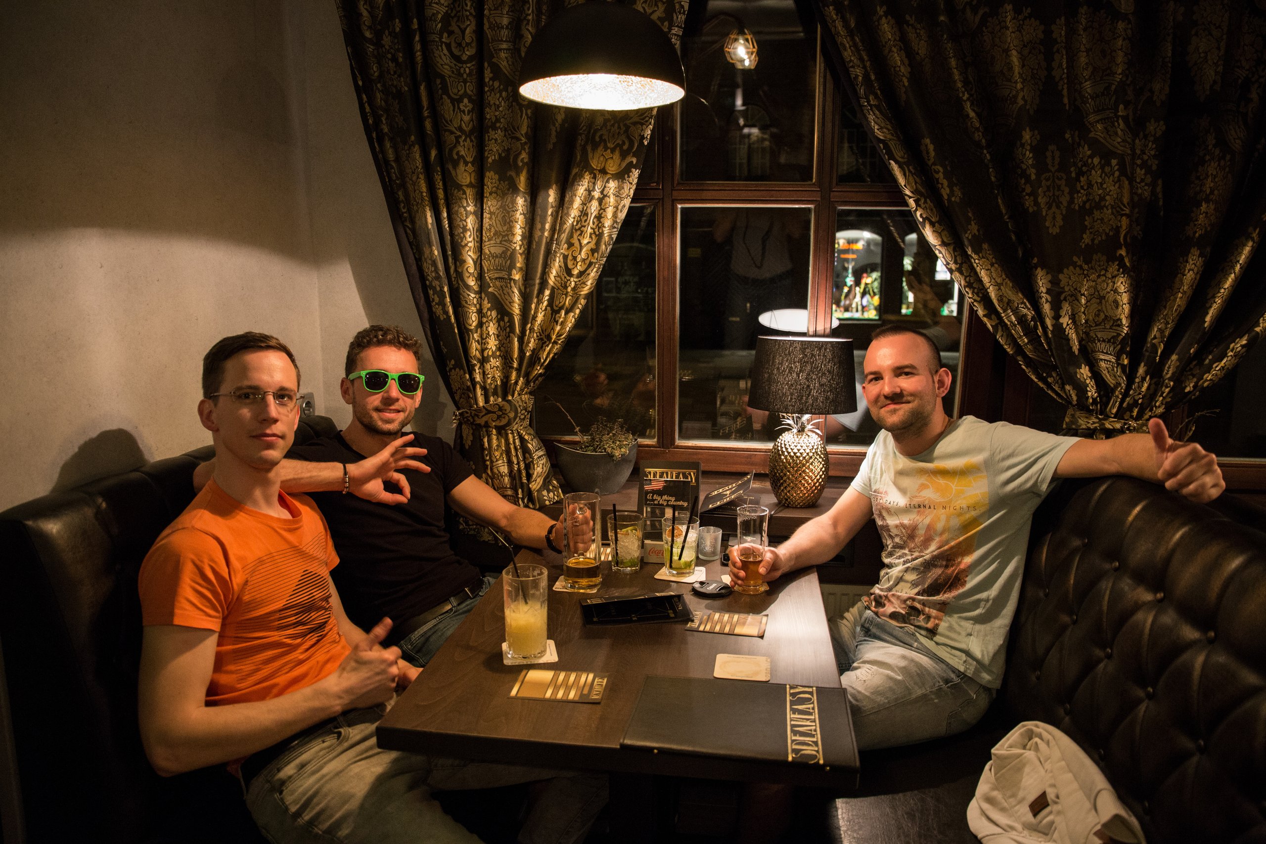 Drei Freunde an einem Tisch in einer Bar, Getränke auf dem Tisch